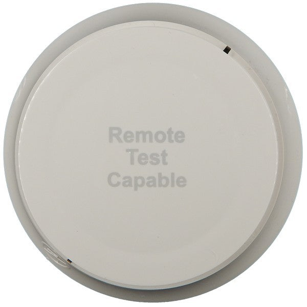 A white, ceiling-mounted smoke detector with the text 'Remote Test Capable' printed on it.