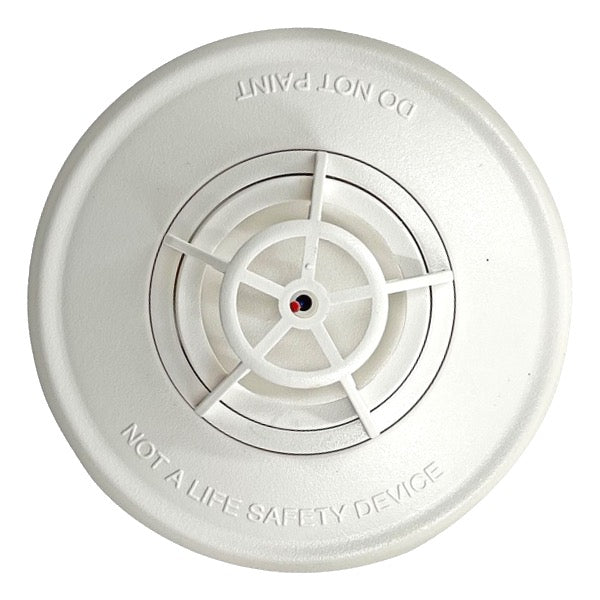 A white, ceiling-mounted Simplex heat sensor with a circular design and a central pivot point.
